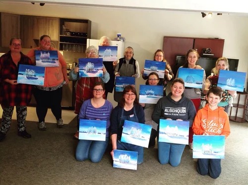Group of people holding their paintings