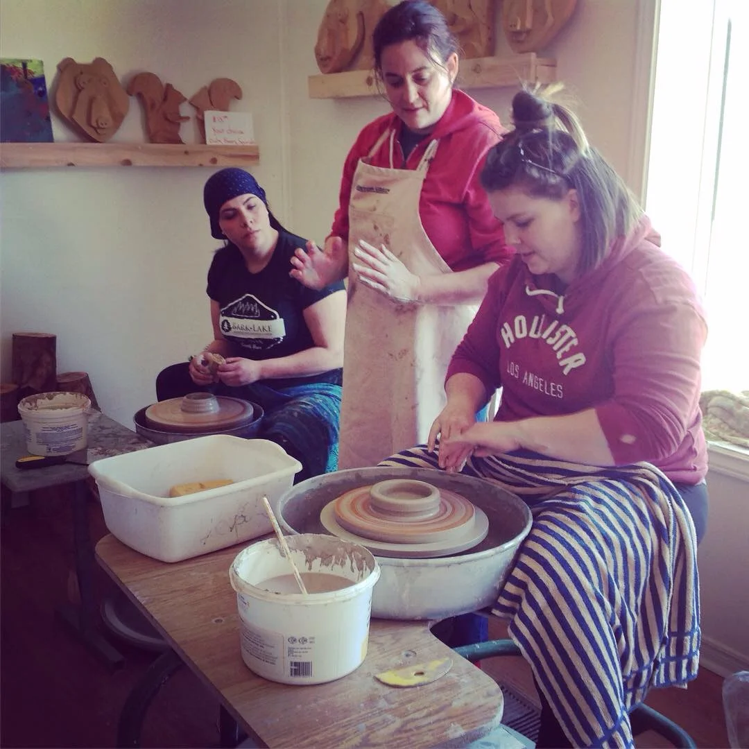 Participant shaping clay on a pottery wheel with guidance during a Kairos Time workshop.