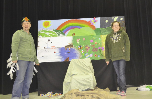 Two participants stand beside a colourful mural during a community arts project in Bancroft, celebrating creativity and inclusion.